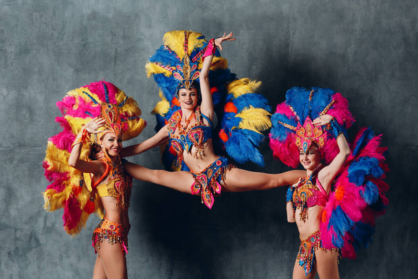 Drie Vrouw in cabaret kostuum met kleurrijke veren verenkleed - Foto, afbeelding