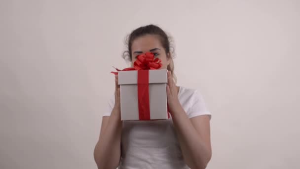 Teenage caucasian girl in white t-shirt holding the gift box - Metraje, vídeo