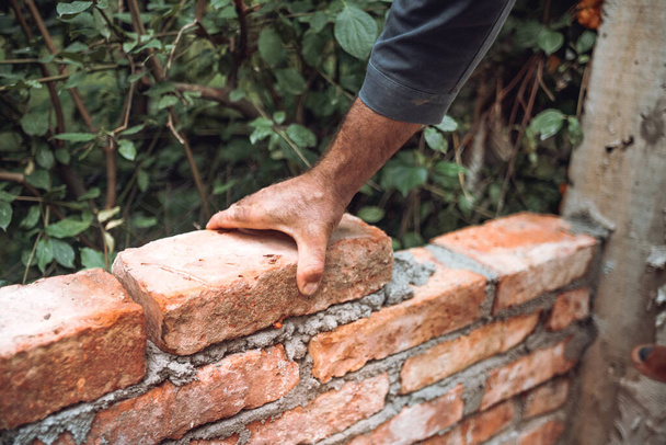 Bricklayer industrial worker installing old  bricks. masonry on exterior wall with old bricks and worker hands - Фото, зображення