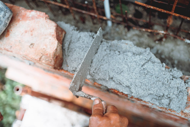 Professional worker using pan knife for building old brick walls with cement and morta - Fotoğraf, Görsel