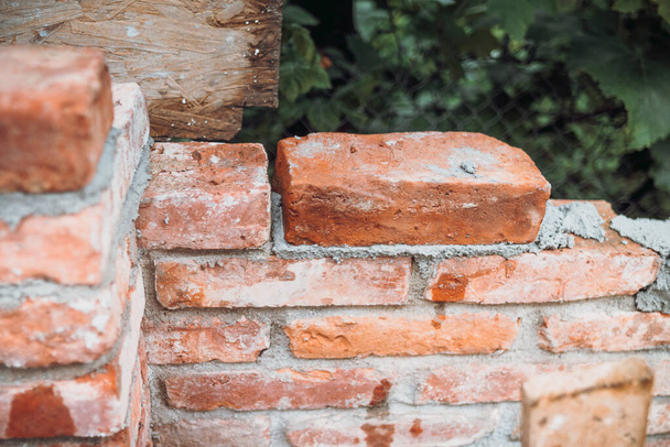 Close up of industrial worker, bricklayer installing bricks on construction site - Φωτογραφία, εικόνα