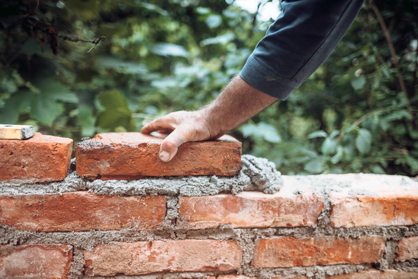 industry details - Construction bricklayer worker building walls with bricks, mortar and putty knif - 写真・画像