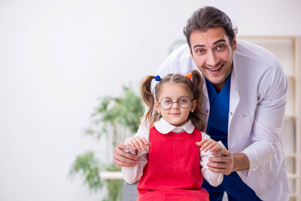 Mała dziewczynka odwiedza młodego lekarza okulistę - Zdjęcie, obraz
