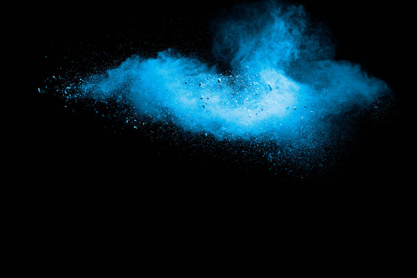 Blauwe achtergrond van krijtpoeder. Blauwe stof deeltjes gespetterd op zwarte achtergrond. - Foto, afbeelding