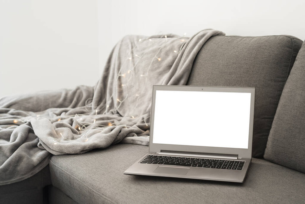 Робота з домашньою концепцією: ноутбук з порожнім білим екраном на сірому дивані
 - Фото, зображення