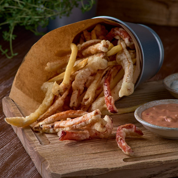 Takeaway food. french fries and vegetables in batter, carrots, sweet peppers, cured and sauces on a wooden board. - Φωτογραφία, εικόνα