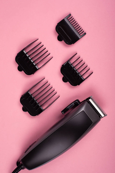 recortadora de cabello sobre fondo rosa, accesorio de peluquería
 - Foto, imagen