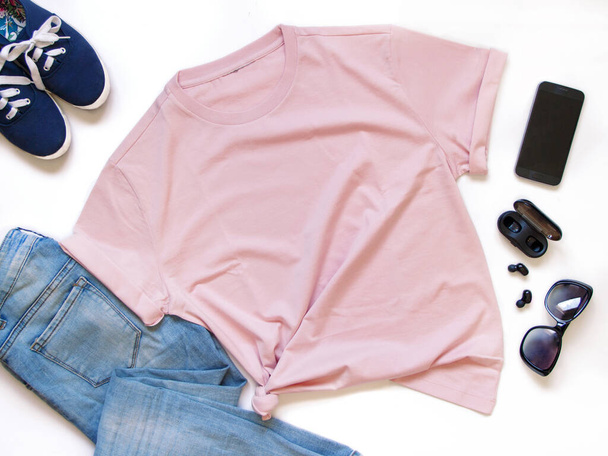 Burla de una camiseta unisex colocada rodeada de accesorios de moda planas
 - Foto, imagen