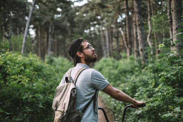 Man bicycler with backpack in a forest. Tourism, active lifestyle. High quality photo - Foto, imagen