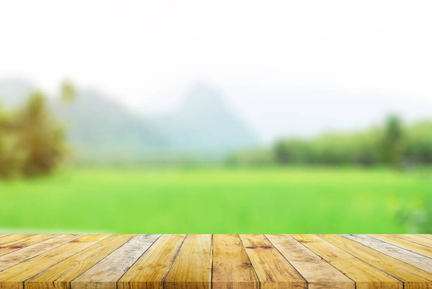 Półka z drewna Brown deski pokładzie z zamazanym zielonym polu ryżu gospodarstwa z góry i chaty tło przyrody. - Zdjęcie, obraz