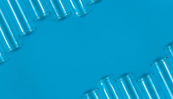 Χημικοί δοκιμαστικοί σωλήνες σε μπλε φόντο με κενό χώρο για το κείμενό σας. - Φωτογραφία, εικόνα