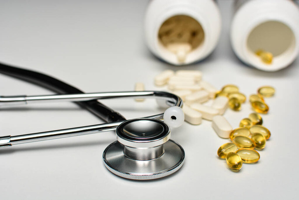 Чорний стетоскоп з таблетками, вітаміном D та вітаміном E. Концепція охорони здоров'я та підтримки імунітету
. - Фото, зображення