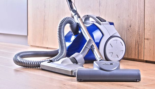 Canister vacuum cleaner for home use on the floor panels in the apartment. - Zdjęcie, obraz