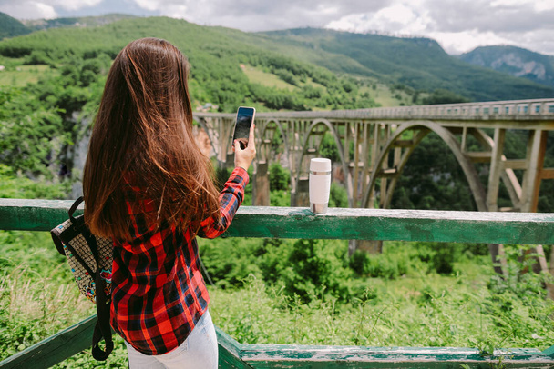 Schöne Reisende mit Smartphone im Urlaub in den Bergen - Foto, Bild