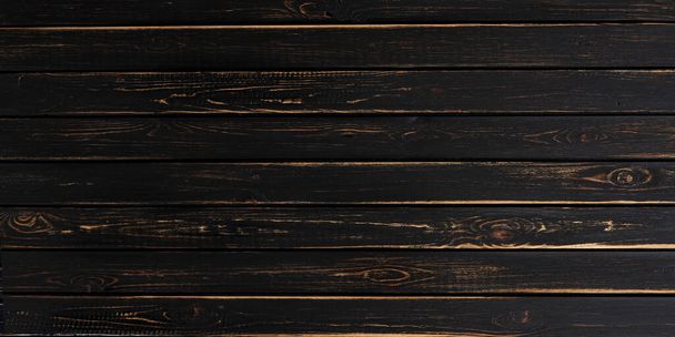 Обветшалая темная деревянная поверхность стола. Фон или текстура черного дерева  - Фото, изображение