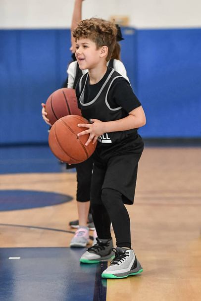 Joven atleta haciendo grandes jugadas de baloncesto durante un juego
 - Foto, imagen