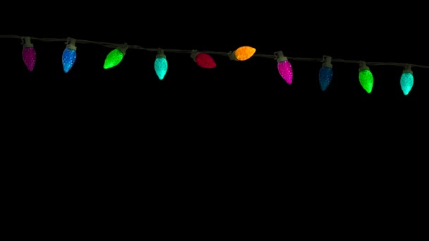 Eine Reihe isolierter bunter Weihnachts- oder Partylichter, die auf schwarzem Hintergrund immer wieder aufleuchten - Filmmaterial, Video