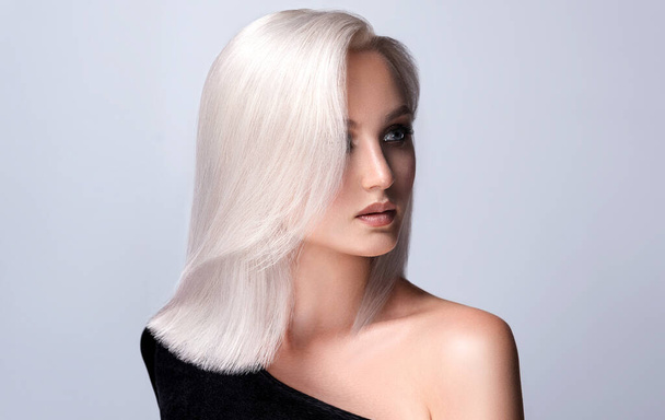 Beautiful girl with dyed hair in blond. Stylish hairstyle done in a beauty salon. Beauty, cosmetics and makeup - Photo, Image
