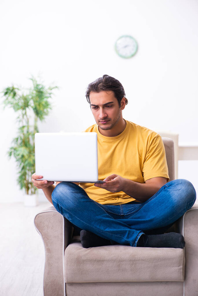 Junger schöner Mann mit Computer zu Hause - Foto, Bild