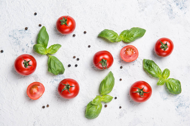 Fresh cherry tomatoes with basil leaves and black pepper on a stone table, vegetable pattern, top view - Foto, immagini