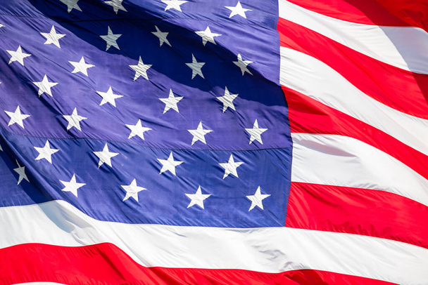 Hermosa bandera americana ondeando en el viento, con vibrantes colores rojo blanco y azul, llenando completamente el marco
. - Foto, Imagen