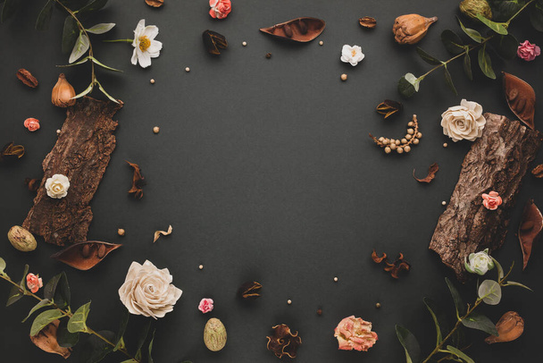 Autumnal-winter concept with dried flowers and leaves, branches of eucalyptus, bark of trees and  berries on dark background. Frame of plants. Flat lay, copy space. - Zdjęcie, obraz