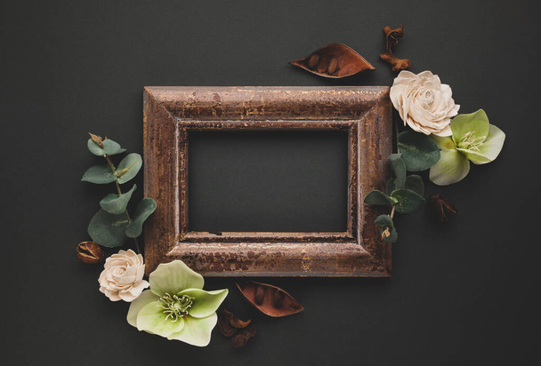 Autumnal-winter composition with vintage frame, dried leaves, bark of trees and berries on dark background.  Flat lay, copy space. - Foto, Imagem