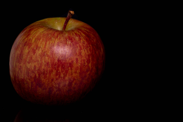 Odizolowane martwe jabłko w miękkim świetle na czarnym tle  - Zdjęcie, obraz