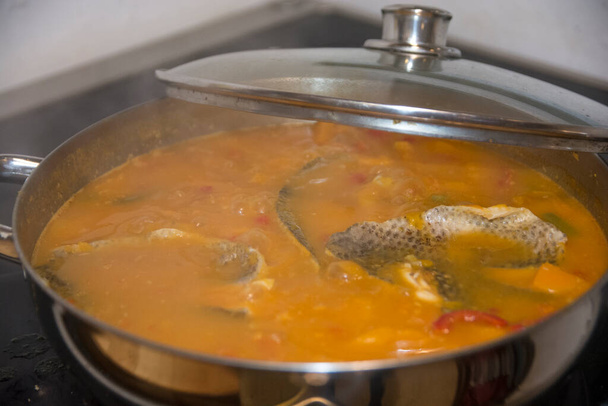 Olla hirviendo de Chraime, una sopa tradicional sefardica del norte de África, con pescado y verduras, principalmente calabaza de mantequilla, cocida en las estufas
. - Foto, imagen