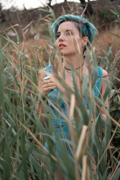 Portret młodej pięknej dziewczyny w niebieskim stroju kąpielowym w zaroślach trzcin - Zdjęcie, obraz