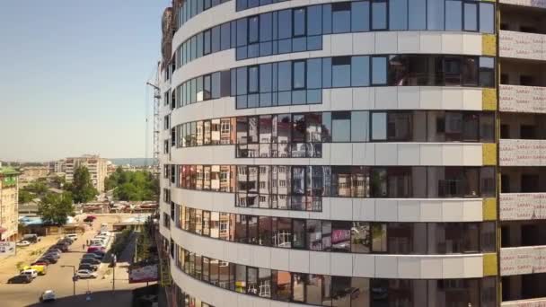  Luchtfoto van betonnen frame van hoog glazen appartementengebouw in aanbouw in een stad. - Video