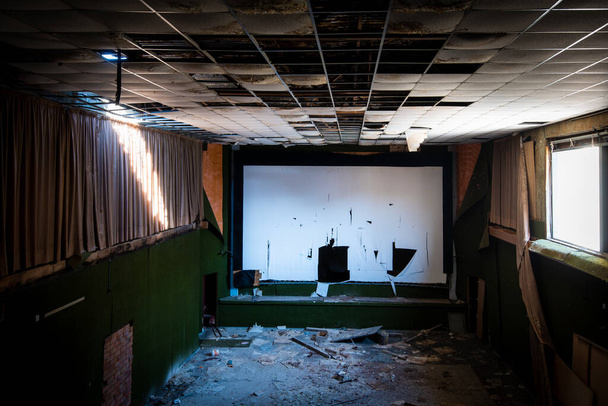 Kıbrıs Rum Kesimi 'ne parlak ışığın girdiği terk edilmiş ve hasar görmüş bir sinema salonu. - Fotoğraf, Görsel