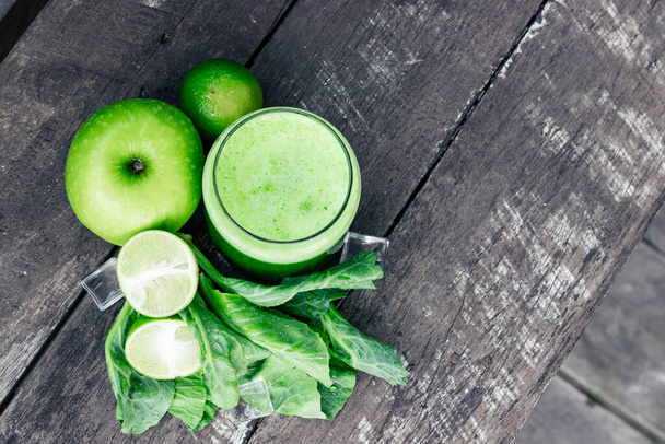 Vihreä omena smoothie lasi ja lehtikaali lehdet maalaismainen puinen pöytä. Summer Detox ravista tausta - Valokuva, kuva