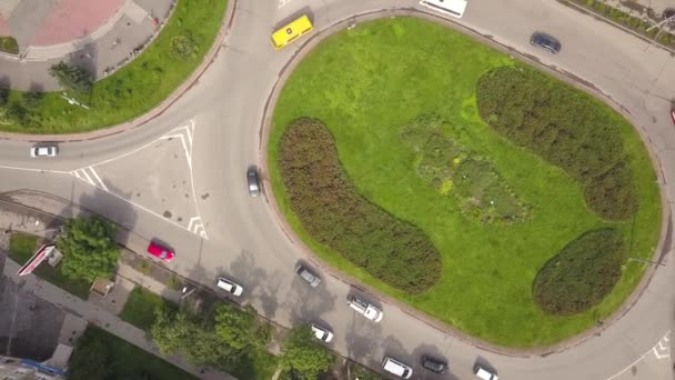 Bovenaanzicht vanuit de lucht op de rotonde kruising met rijdend autoverkeer. - Video