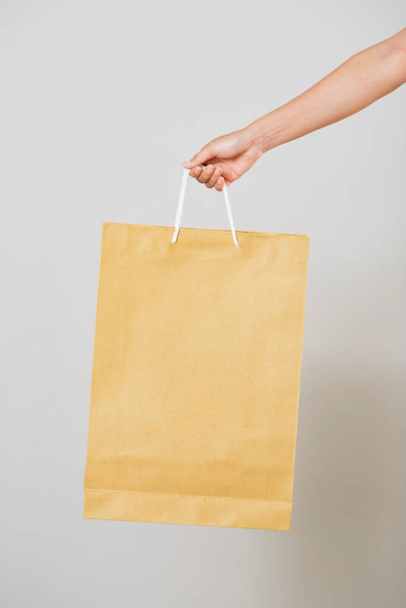 женщина рука держать бумажный пакет покупки мешок на белом, обрезка пути, торговый концепт, - Фото, изображение