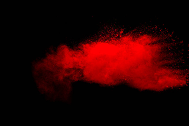 Abstract red dust explosion on black background. Freeze motion of red powder splash. - Photo, Image