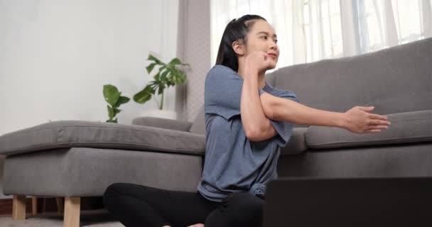 Sportovní mladá asijská žena dělá strečink a sledování fitness video tutorial on-line na notebooku s činkami v obývacím pokoji, Sport doma školení, on-line fitness třída, zdravý životní styl. - Záběry, video