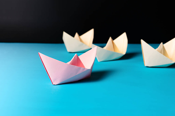 Vezetői koncepció, rózsaszín papírhajó vezető sárga hajó csapat tagja - Fotó, kép