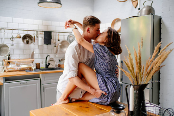 couple hugging at home in kitchen. newlyweds on honeymoon. - Zdjęcie, obraz