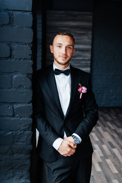 Portraits of the groom at the hotel training camp, dressed as a businessman in a black suit, tuxedo and white shirt - Фото, зображення