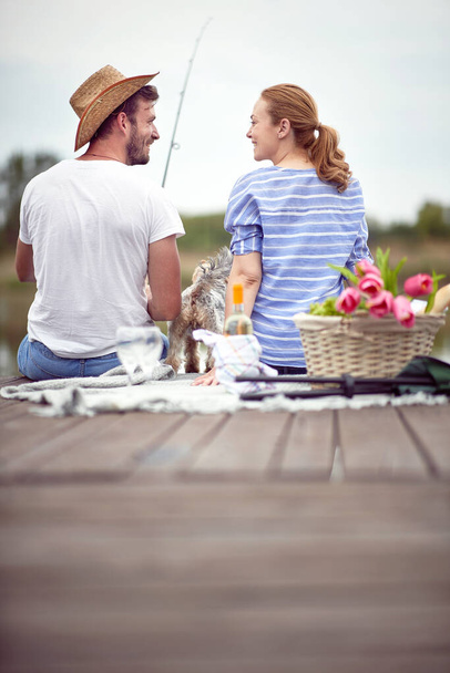 young adult caucasian couple at picnic by the lake fishing - Foto, Imagem