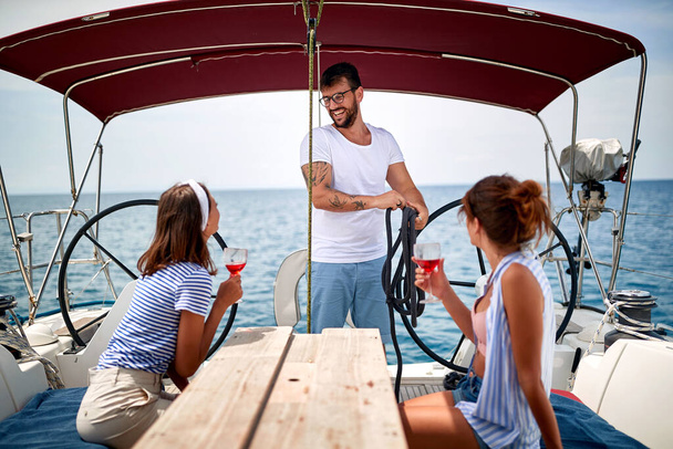 Friends chill on a yacht on open sea - Фото, зображення