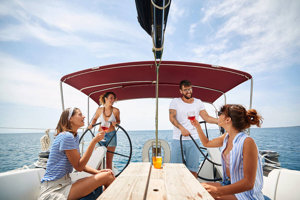 Friends chill with wine on a yacht on a beautiful weather - Foto, afbeelding