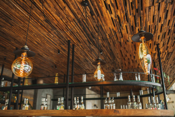 Creatividad diseñada diferentes formas lámparas bombilla eléctrica en la decoración interior del restaurante. Café bar fondo borroso
. - Foto, Imagen