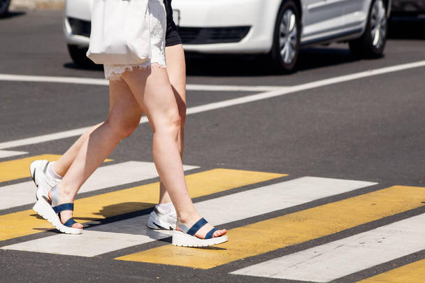 nuoret naiset ylittämässä tietä jalankulkijoiden risteyksessä aurinkoisena kesäpäivänä - Valokuva, kuva