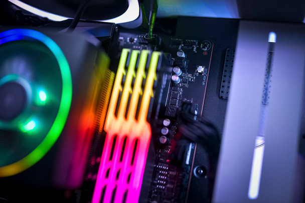 Nahaufnahme eines Computermotherboards, RGB-Speichers und RGB-CPU-Lüfters - Foto, Bild