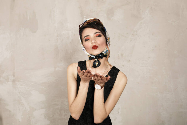 RETRO IMAGE прекрасної красивої жінки в ретро носовичках і чорна сукня посилає повітряний поцілунок. AIR KISS КОНСЕПТ
. - Фото, зображення