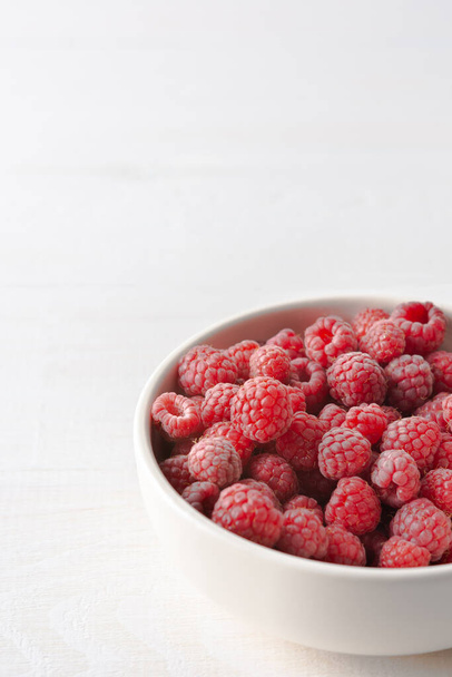 Raspberries close-up in bowls on a white background, ripe juicy berries - Photo, Image