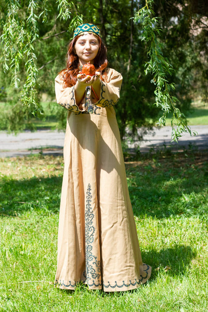 Ormanda geleneksel giysiler içinde, nar kokulu Ermeni bir kadın. - Fotoğraf, Görsel