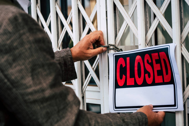 Закрыть делового человека с закрытой вывеской возле магазина и закрыть магазин - Фото, изображение